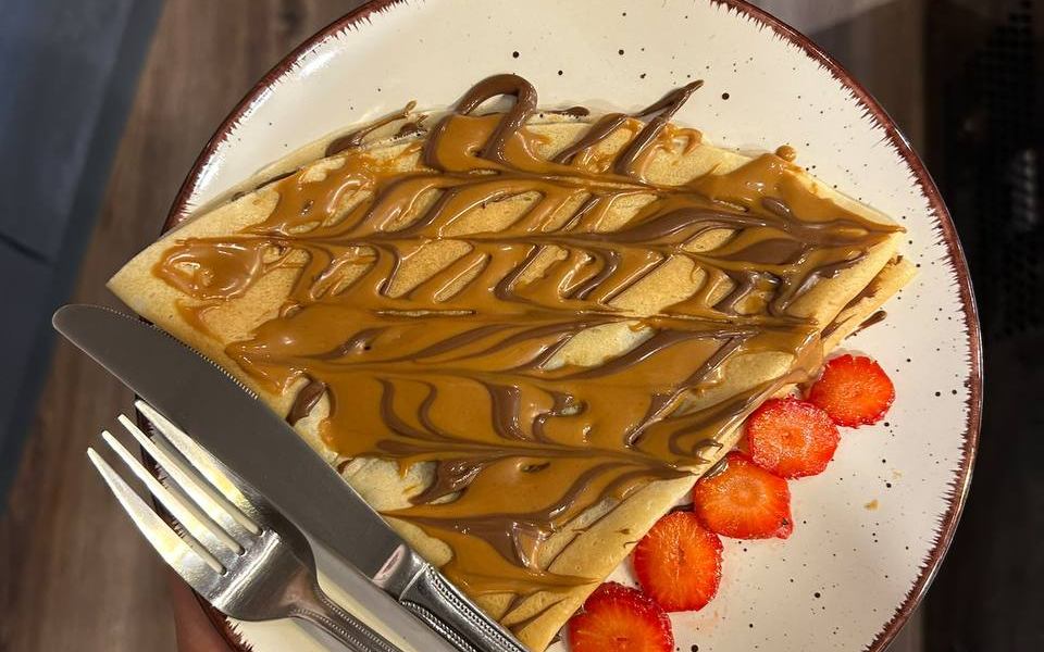 Crêpe mit Karamell- und Schokosauce und Erdbeeren
