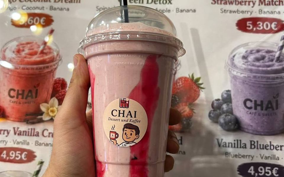 Frucht-Mix im CHAI Becher vor der Frucht-Mix Tafel