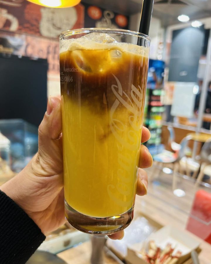 Iced Latte im Glas, in der Hand gehalten