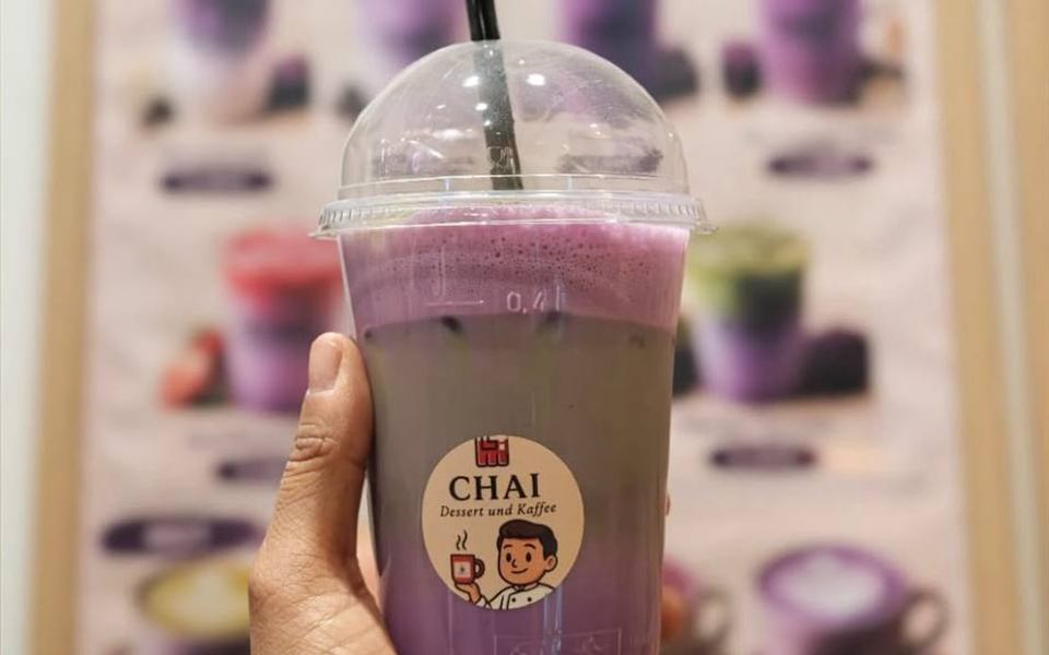 Ube Getränk im CHAI Becher vor der Ube Menütafel